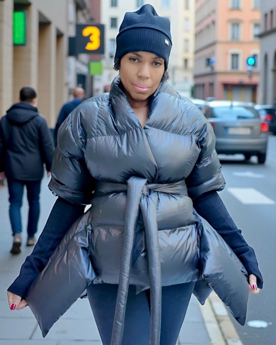 Woman wearing a tie-waist quilted puffer coat in the city during winter